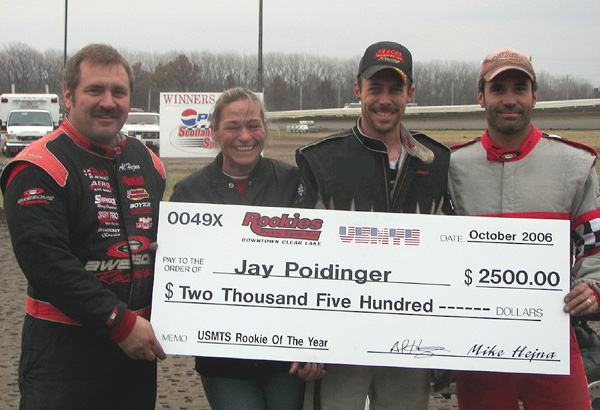 Rookies Rockin' Sports Bar Rookie of the Year Jay Poidinger, along with his wife Denise, accepts his ceremonial check from Rookies Rockin' Sports Bar owners Al Hejna (left) and brother Mike Hejna (right).